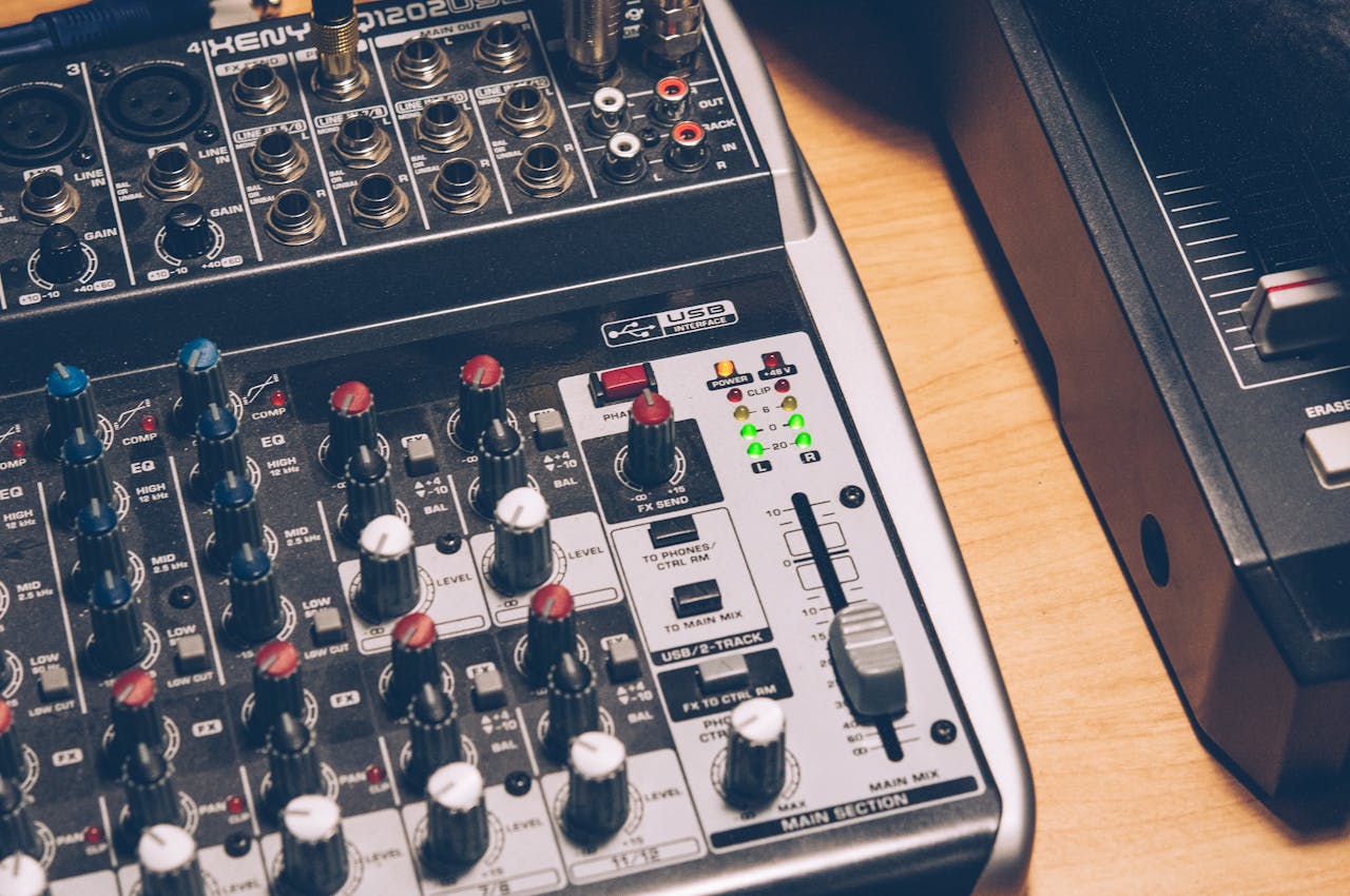 Close-up of an audio mixing console with knobs and switches, ideal for music production.