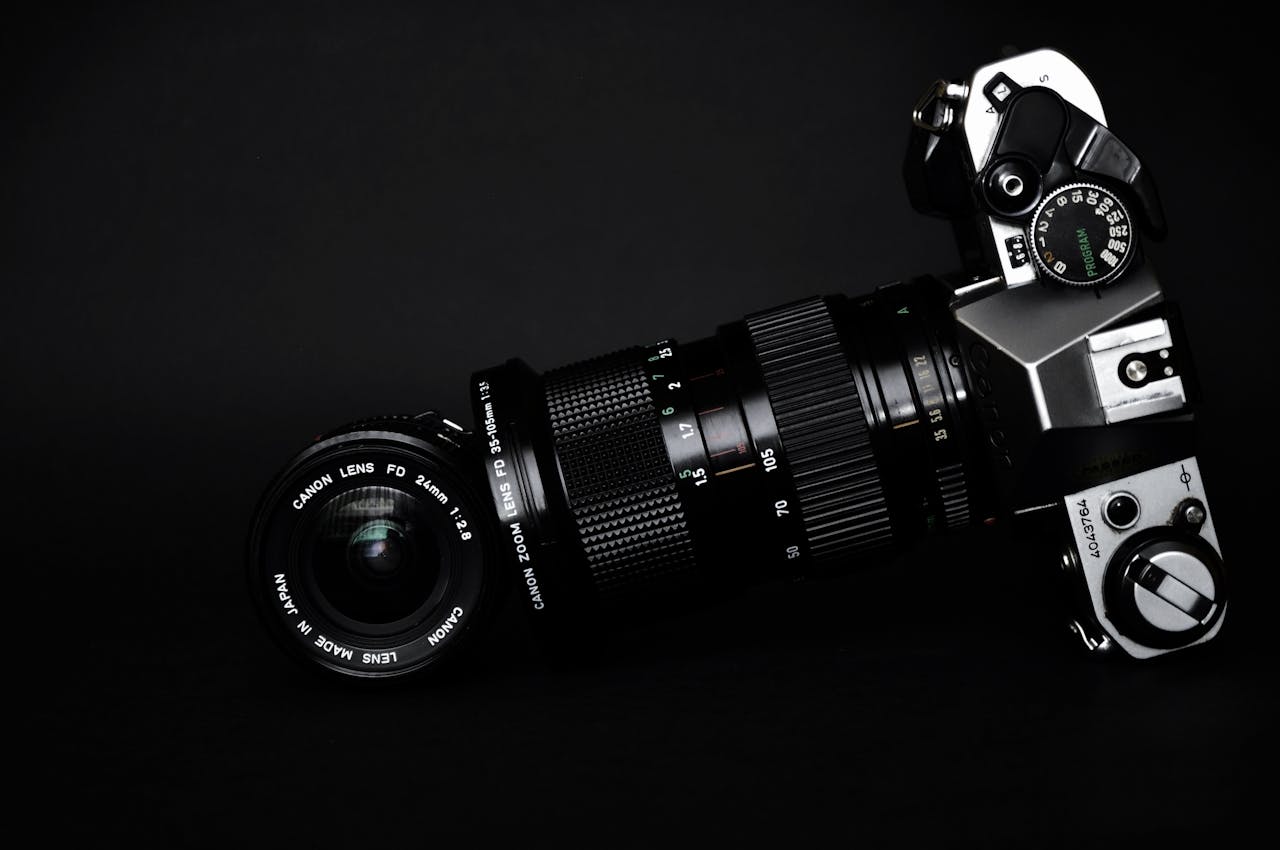 Close-up of a classic camera with lens against a black background, showcasing photography equipment.